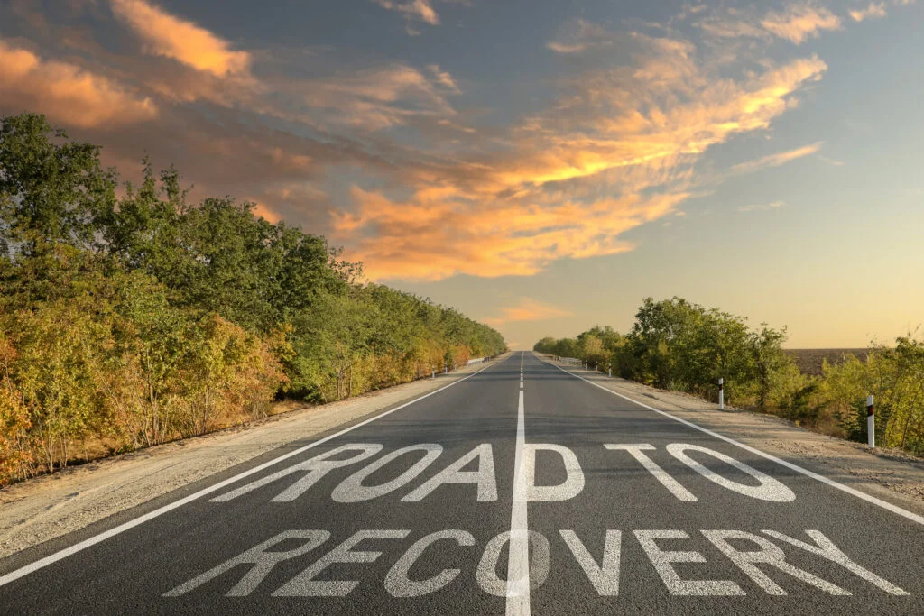 Phrase ROAD TO RECOVERY on asphalt highway