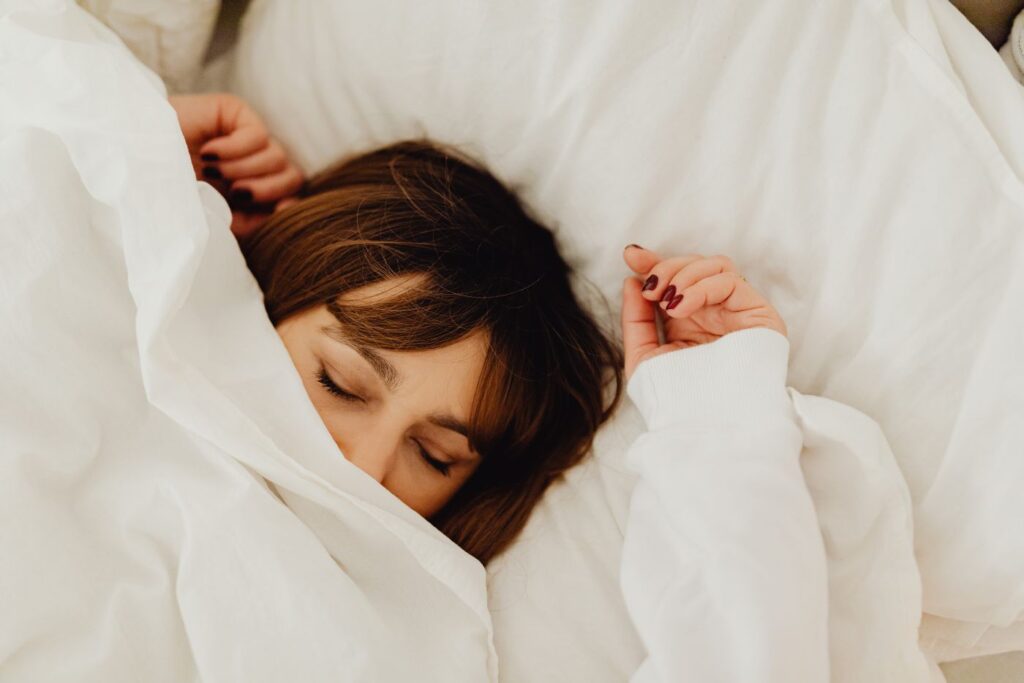 Woman sleeping peacefully in white bedding