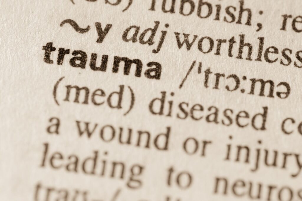 Close-up of the word trauma in dictionary.
