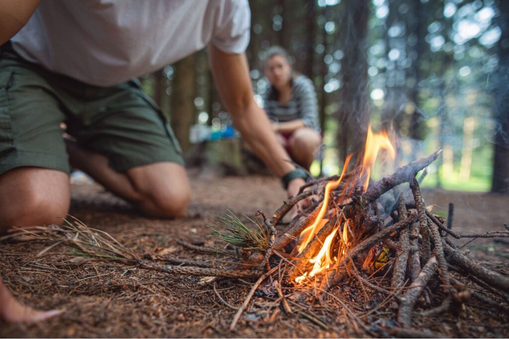 People starting a campfire in the forest
