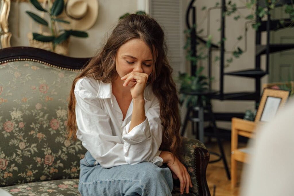 Woman sitting on couch looking stressed