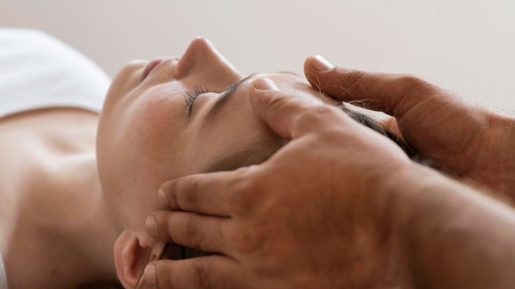 Person receiving facial massage with eyes closed